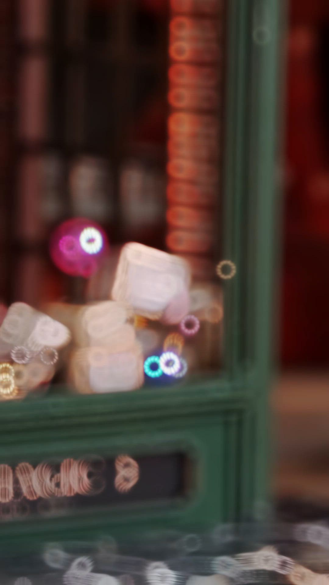 This may contain: blurry image of dices in front of a store window with lights behind them