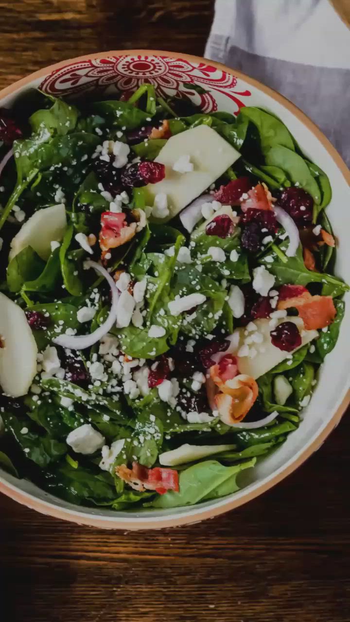 This may contain: an apple cranberry thanksgiving salad in a bowl