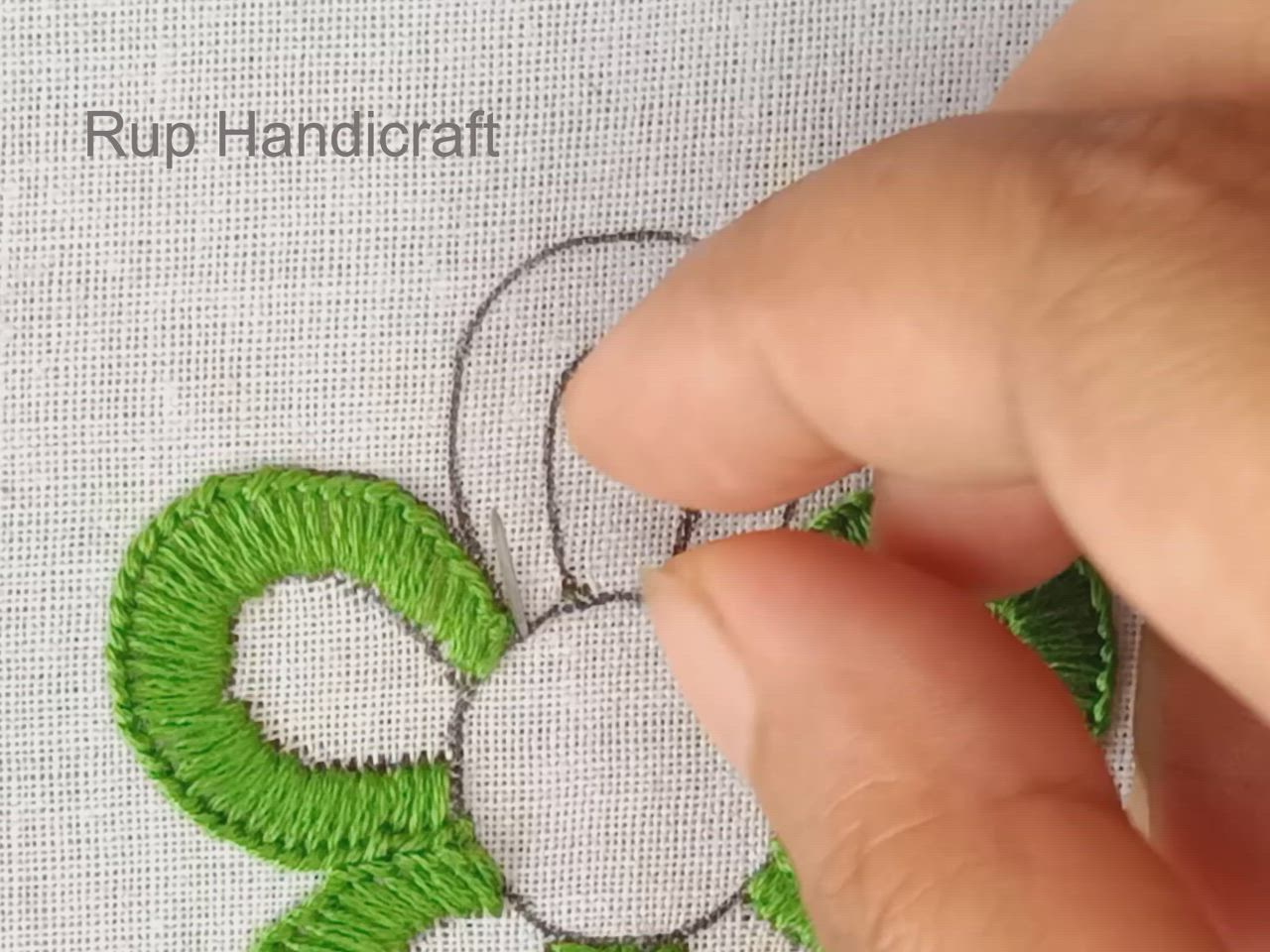 This may contain: someone is stitching the flower with green thread