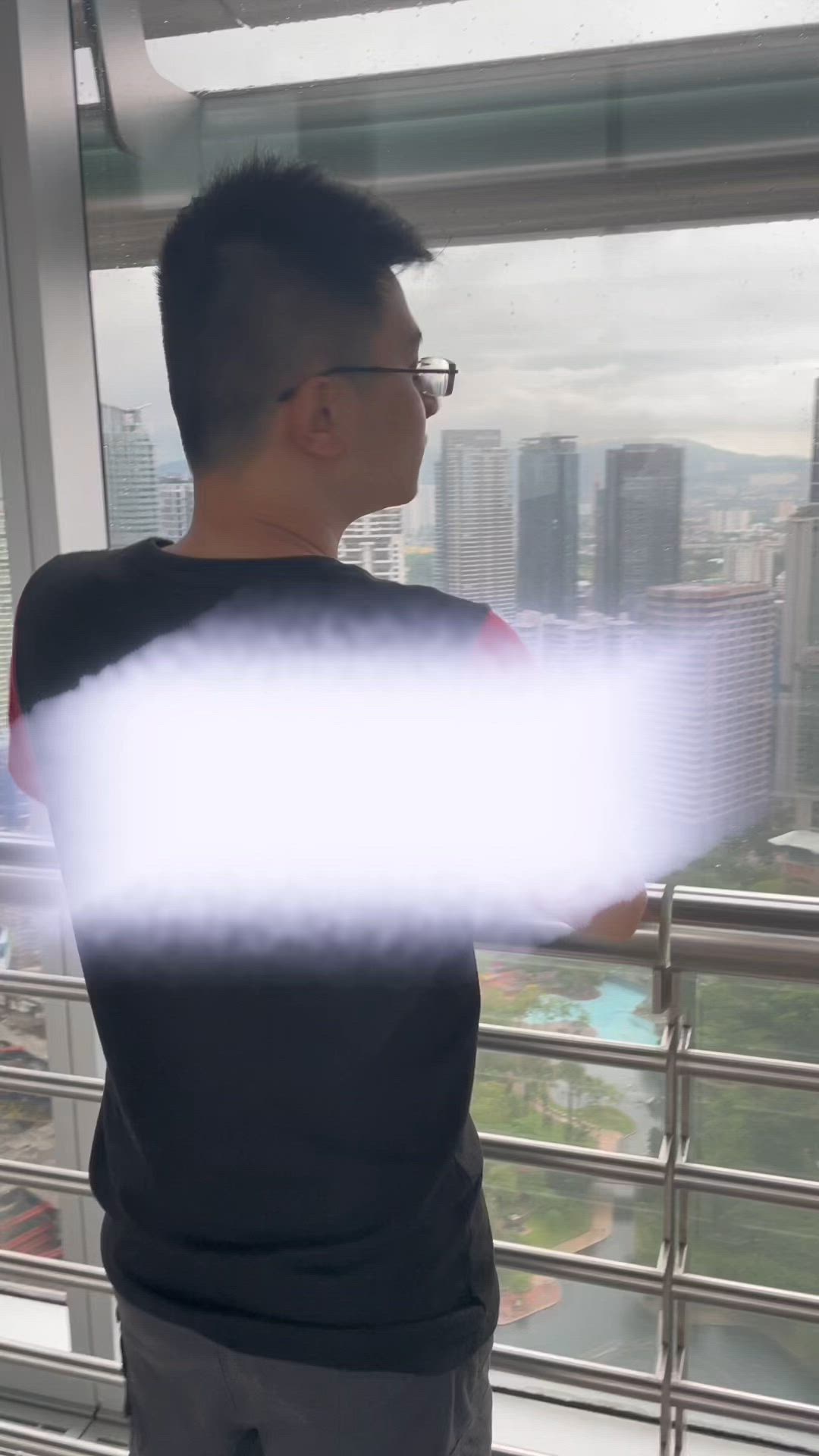 This may contain: a man standing in front of a window with a light beam coming out of it