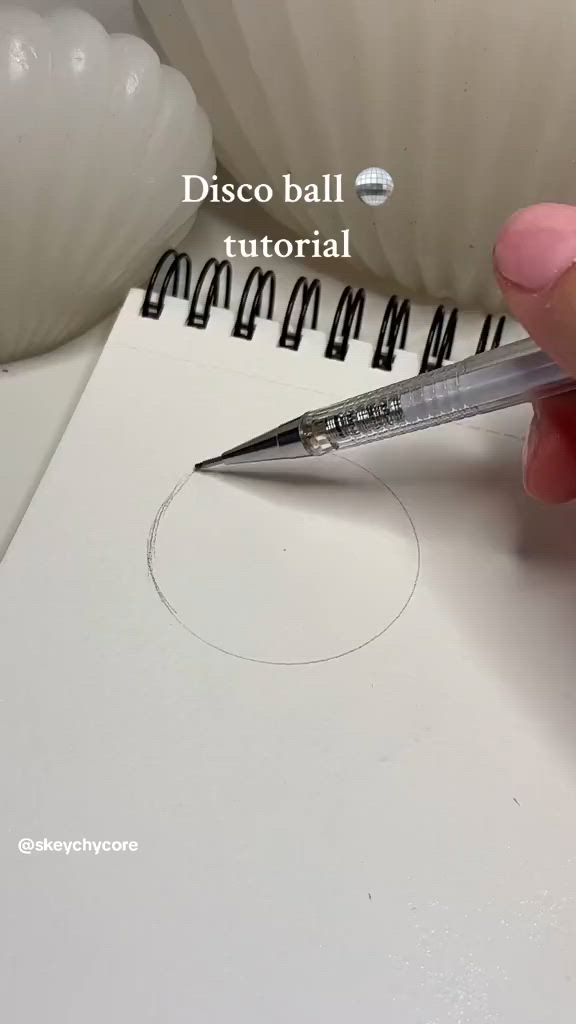 This may contain: someone is drawing a basket ball on a piece of paper with a pen and scissors