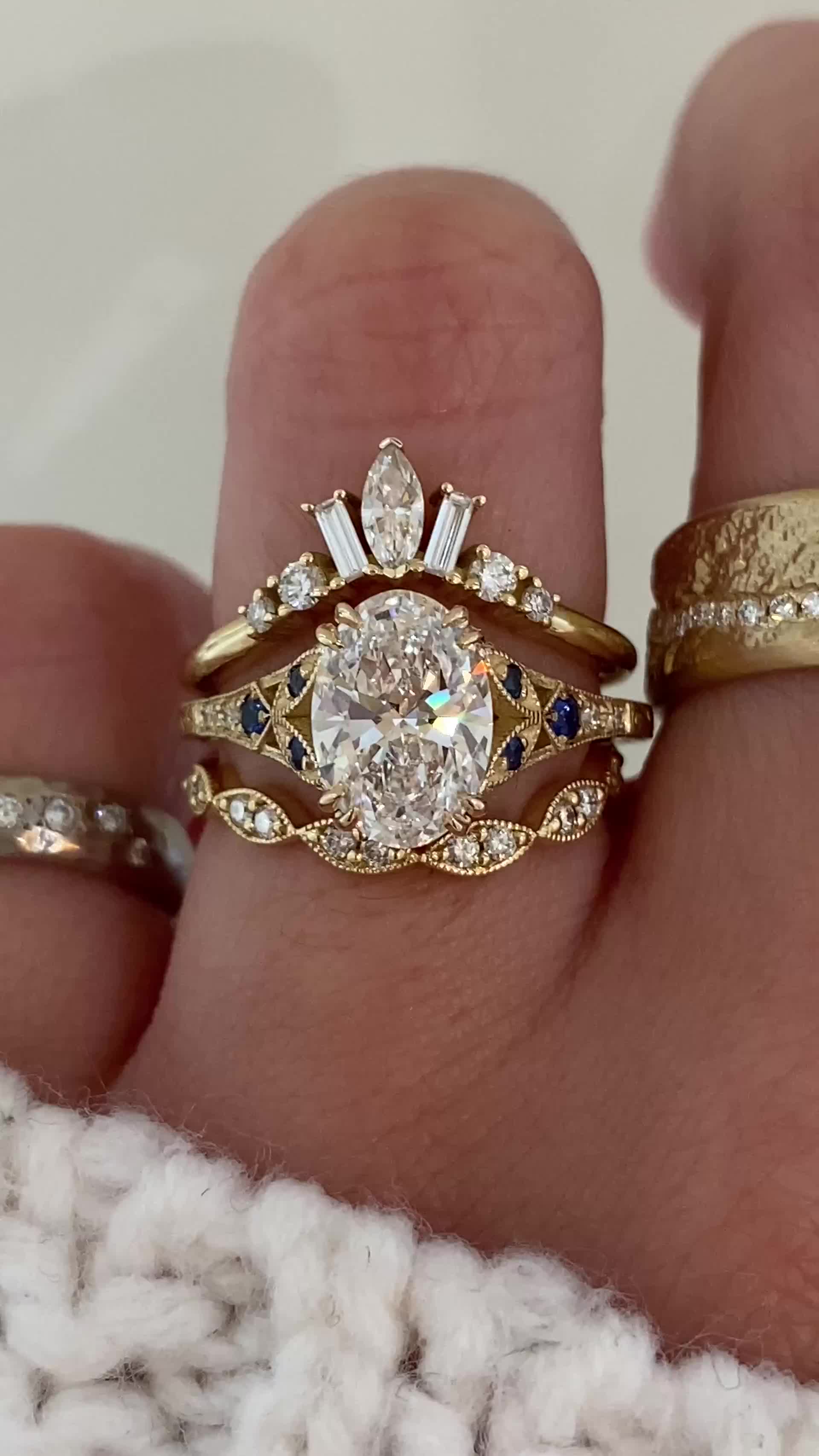 This may contain: a woman's hand with two gold rings and one diamond ring on her finger