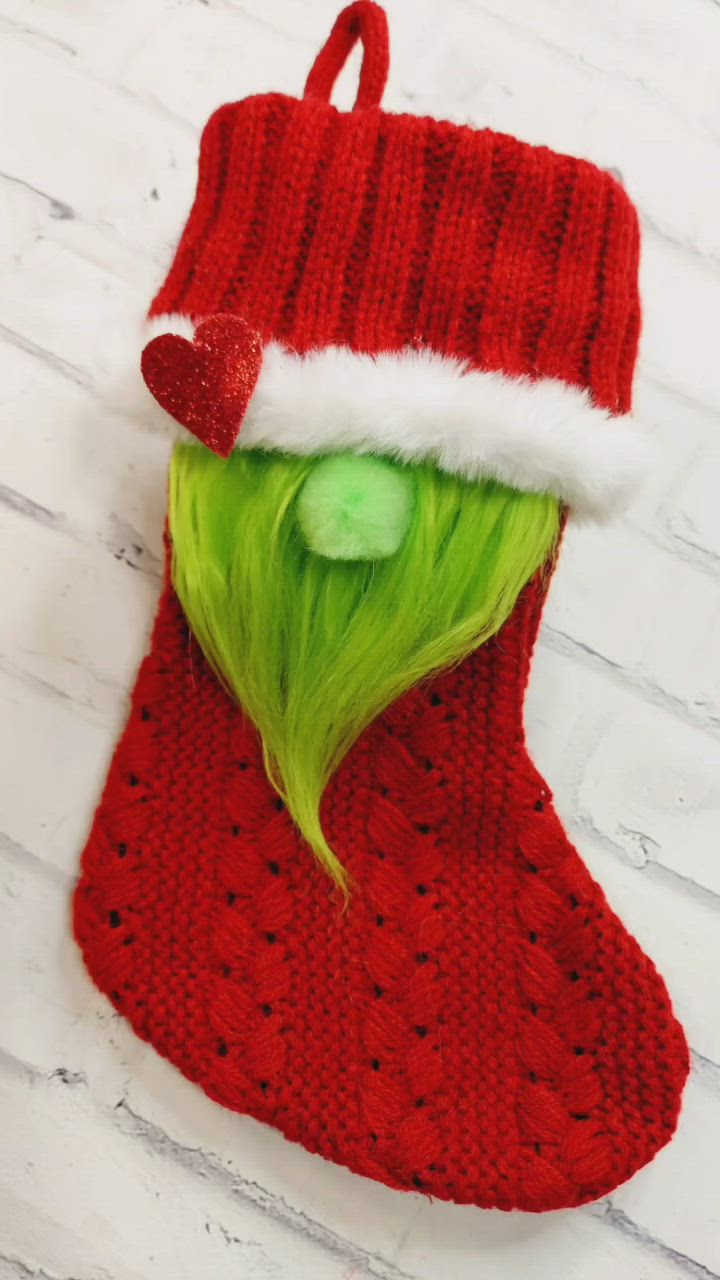 This may contain: a knitted christmas stocking with green hair