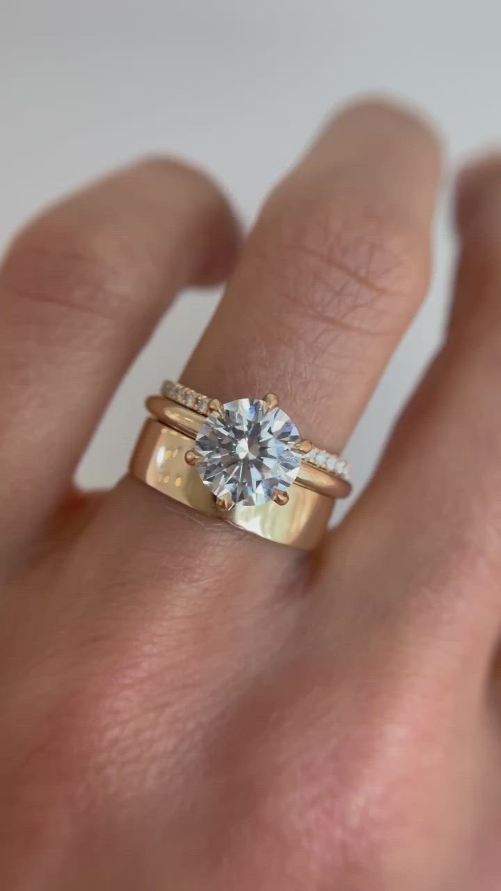 This may contain: a woman's hand with a ring on it and a diamond in the middle