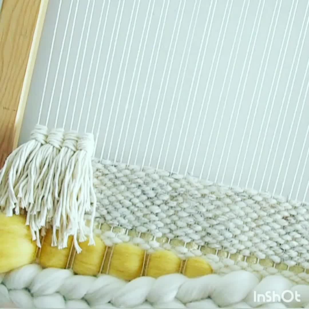 This may contain: a close up of a weaving machine with yellow and white yarn on the bottom half