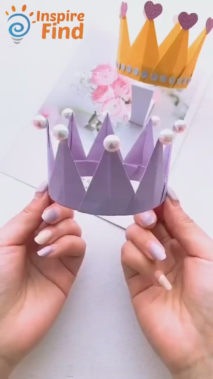 This may contain: two hands holding up a paper crown