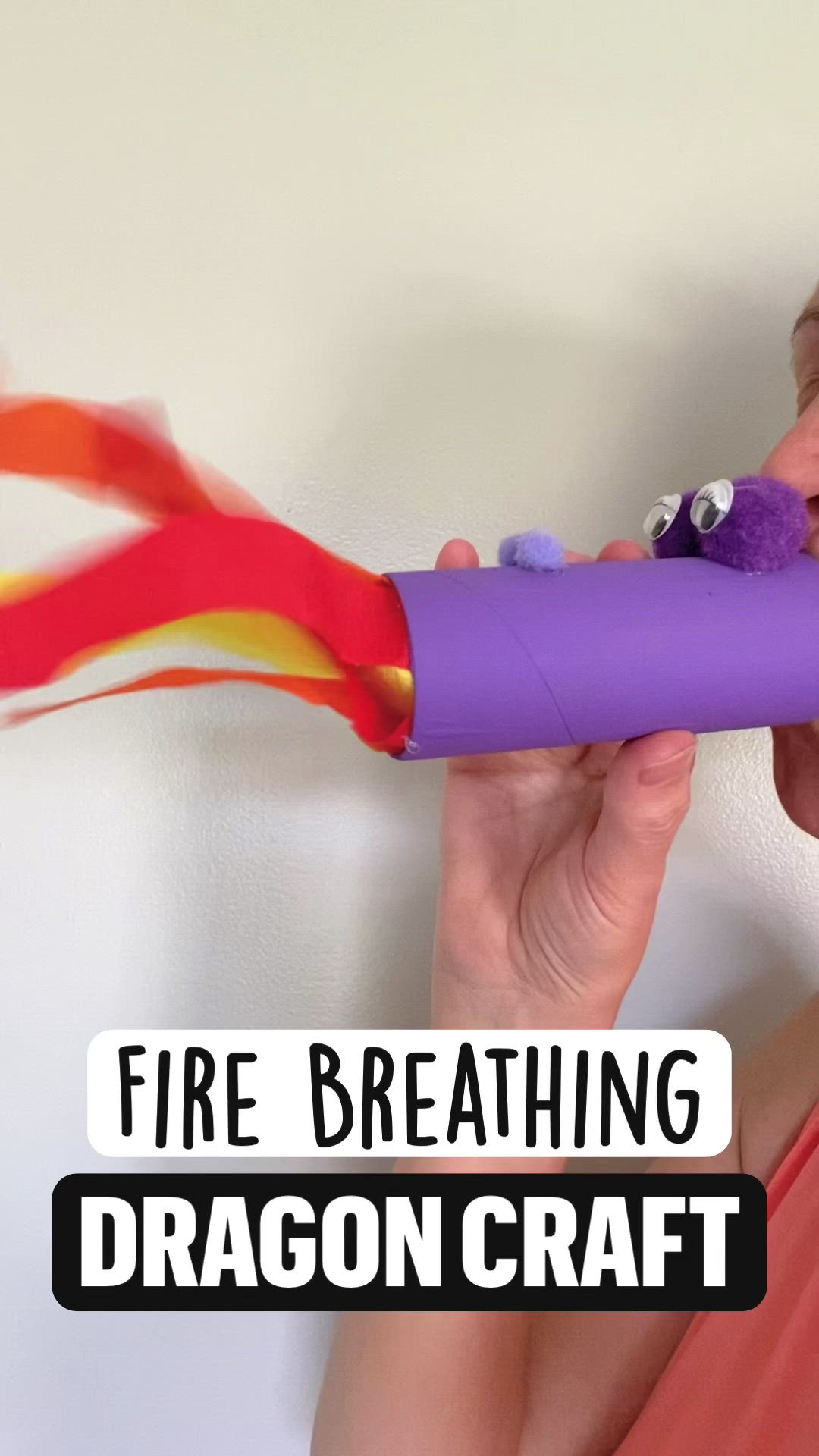 This may contain: a woman holding a fire breathing dragon craft in front of her face with the words, fire breathing dragon craft