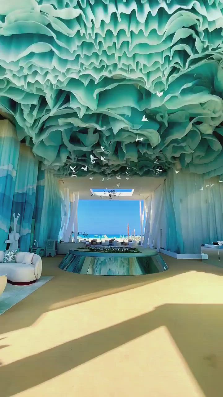 This may contain: an artistic room with blue and white curtains on the ceiling, water in the middle