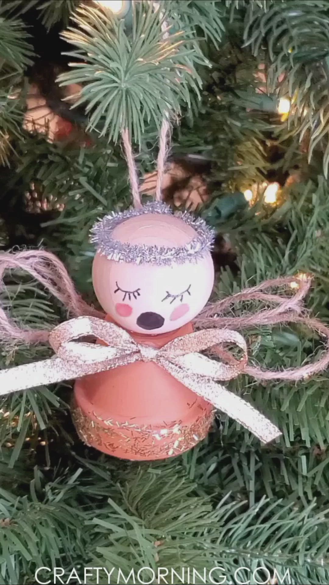 This may contain: an angel ornament hanging from a christmas tree