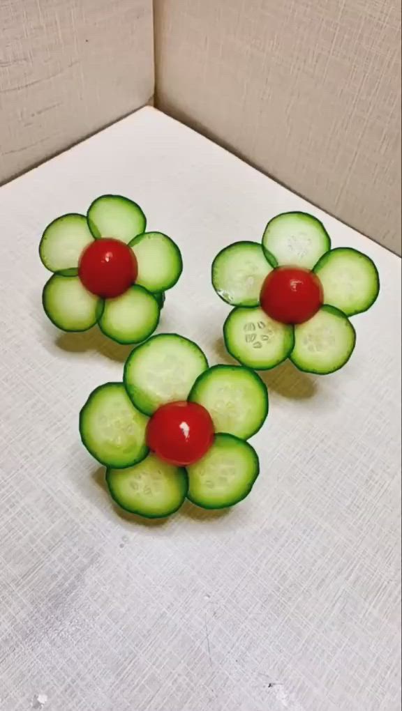 This may contain: two pieces of cucumber with a cherry on top are sitting next to each other