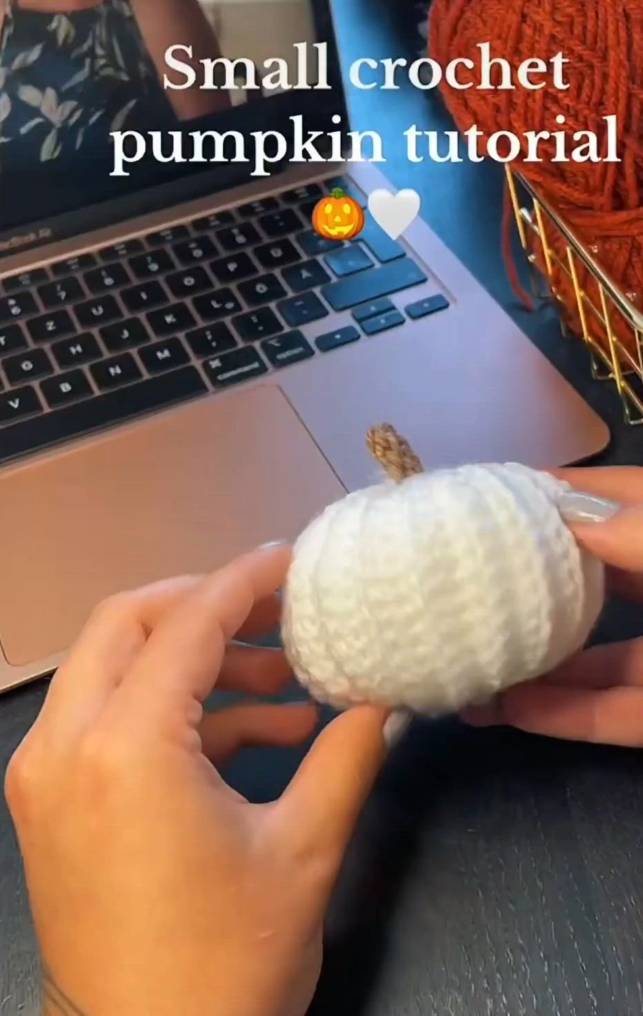 This may contain: someone is holding a small pumpkin in front of a laptop computer with the caption, small crochet pumpkin tutor