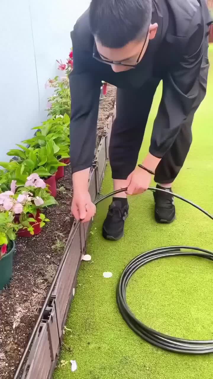 This may contain: a man is using a garden hose to water plants