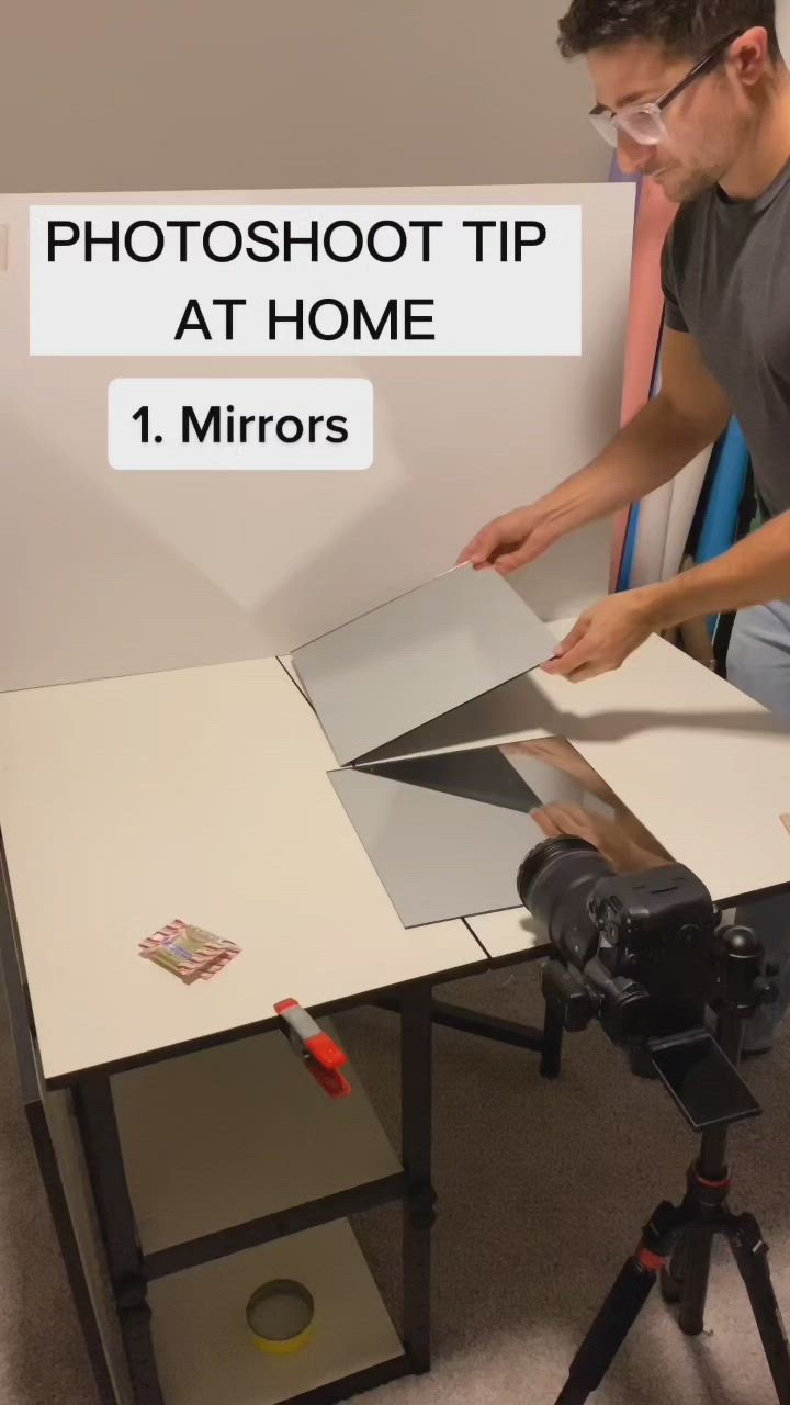 This may contain: a man is cutting up some pictures on a table with a camera and tripod