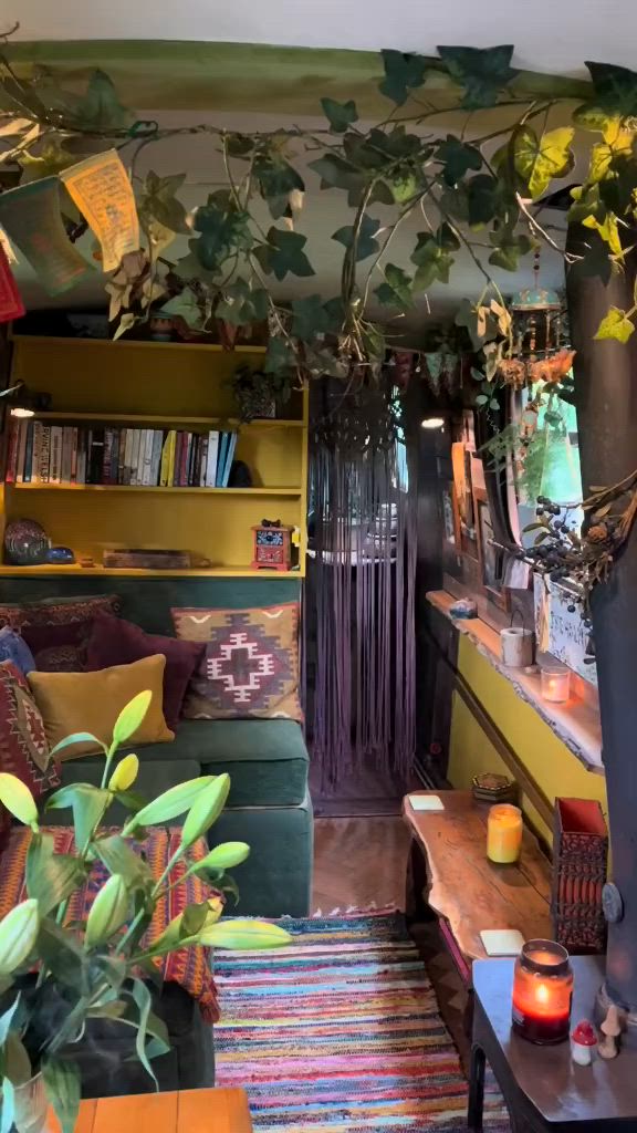 This may contain: a living room filled with lots of furniture and plants on the wall above it's bookshelf