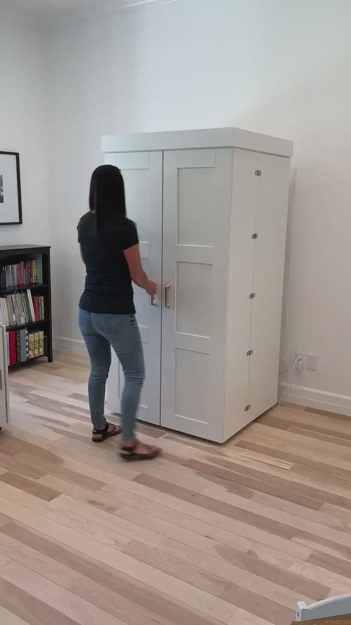 This may contain: a woman standing in front of a white refrigerator freezer next to a wooden floor