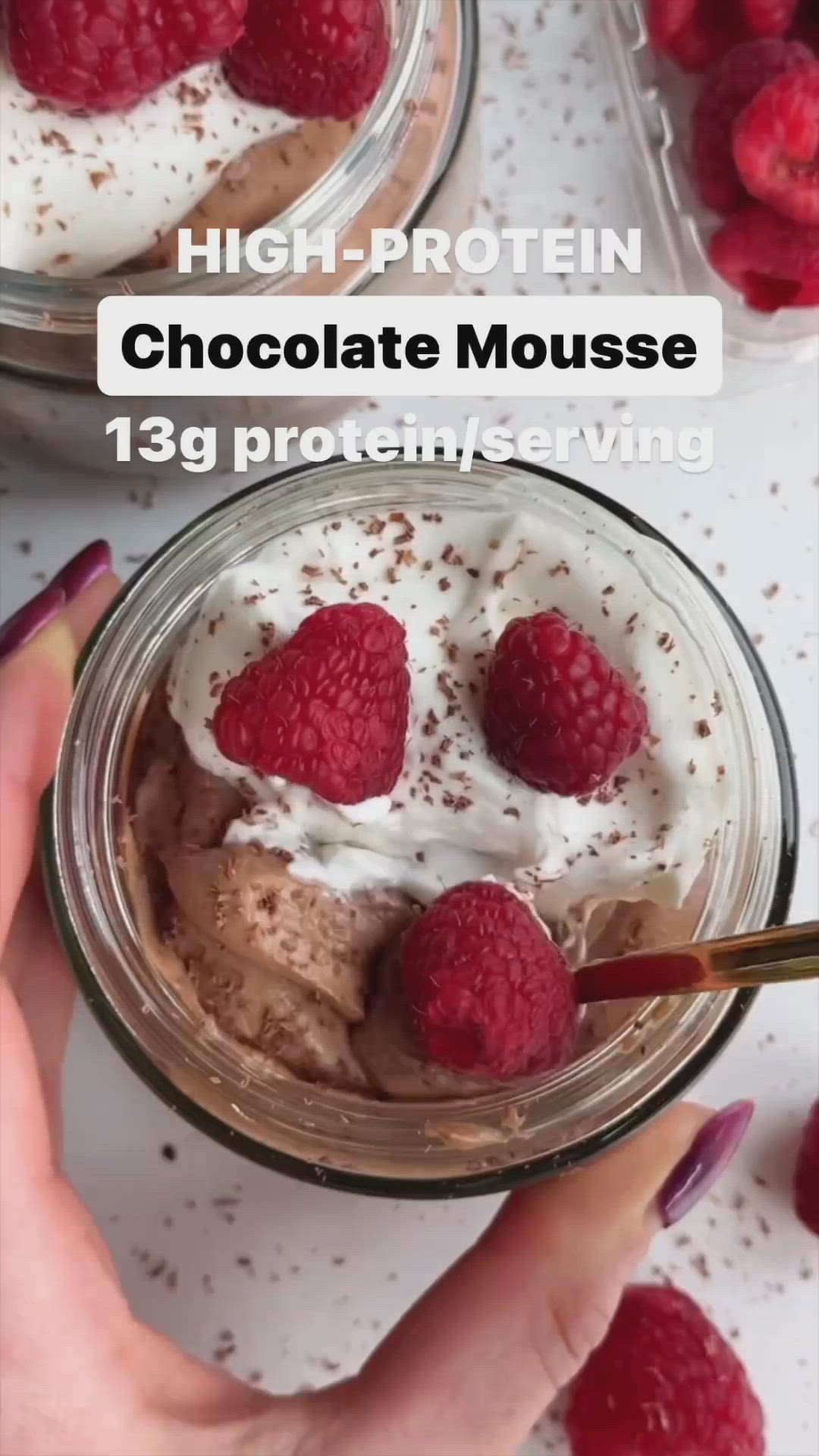 This may contain: chocolate protein mousse in a jar with raspberries