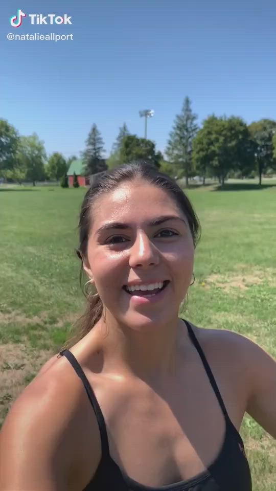 This may contain: a woman standing in front of a green field