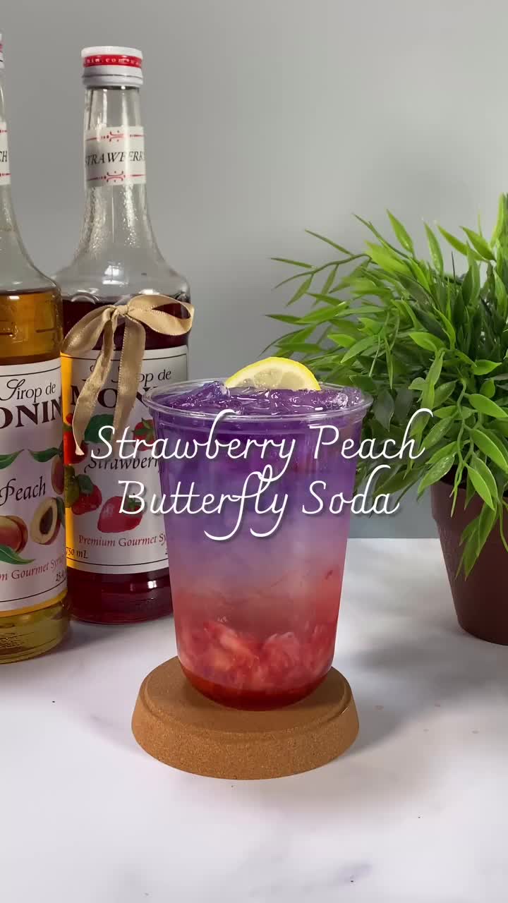 This may contain: a bottle of strawberry peach butterfly soda next to two bottles of lemonade and a potted plant