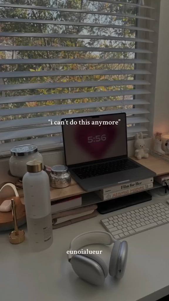 This may contain: a laptop computer sitting on top of a desk next to a keyboard and headphones