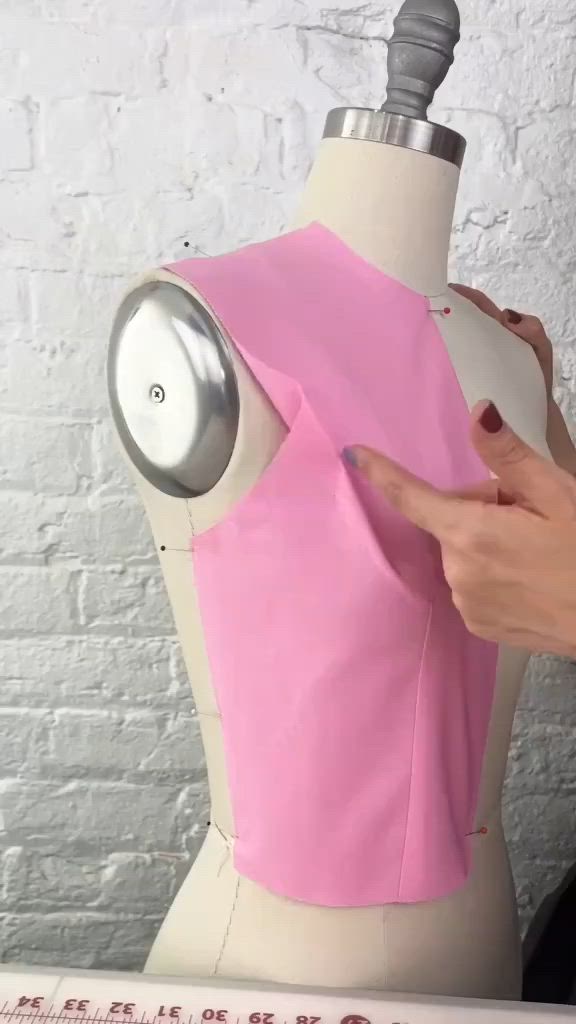 This may contain: a woman is making a pink dress on a mannequin's head and neck