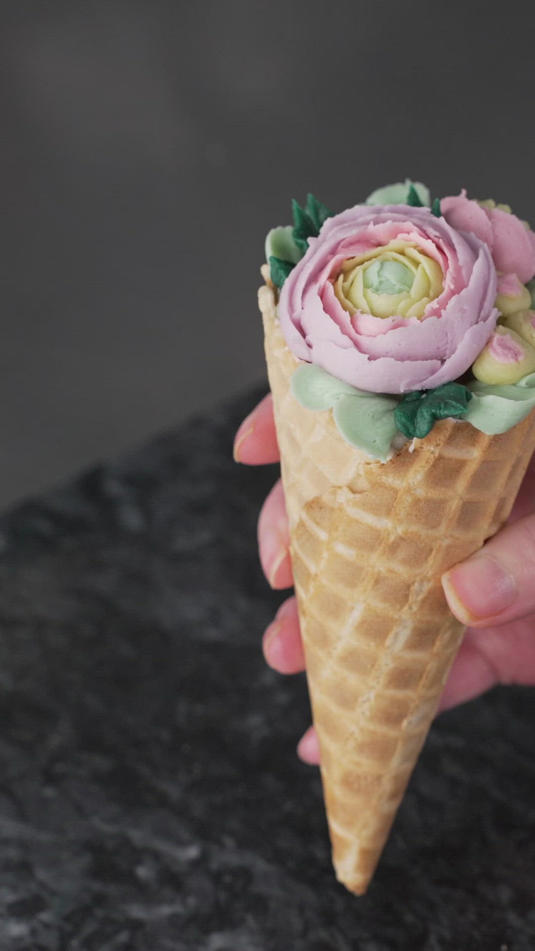 This contains: In this video we will show you how make ranunculus Waffle Cone Bouquets!  These lovely treats are a great way to practice your piping skills and show off your results.