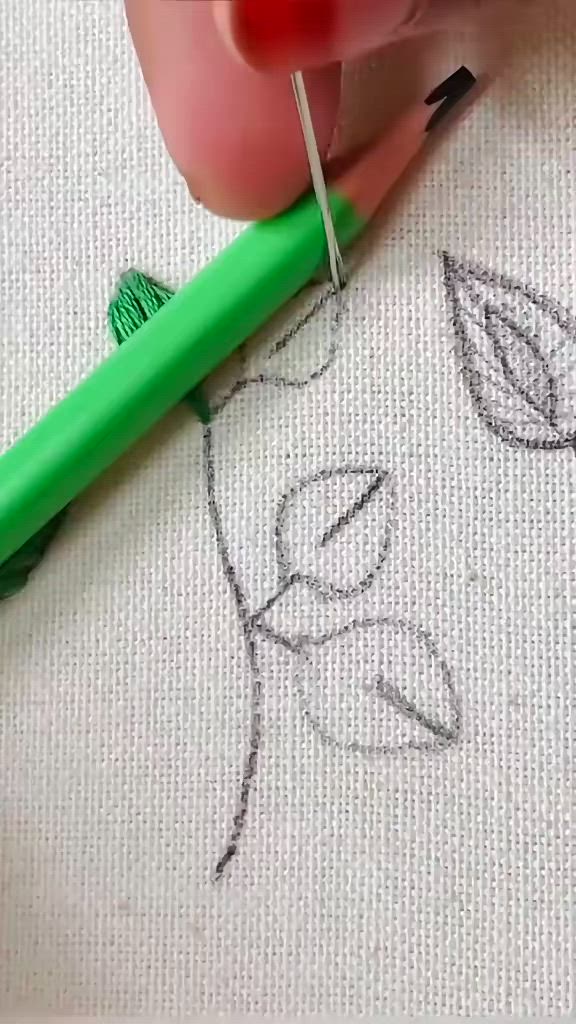 This may contain: a close up of a green pen on a piece of fabric