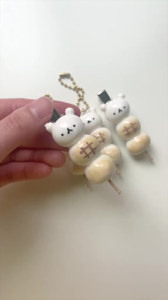 This may contain: a person is holding several small white bears with crosses on them, as if they were made out of marshmallows