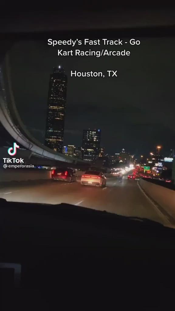 This may contain: the dashboard of a car driving down a highway at night with city lights in the background