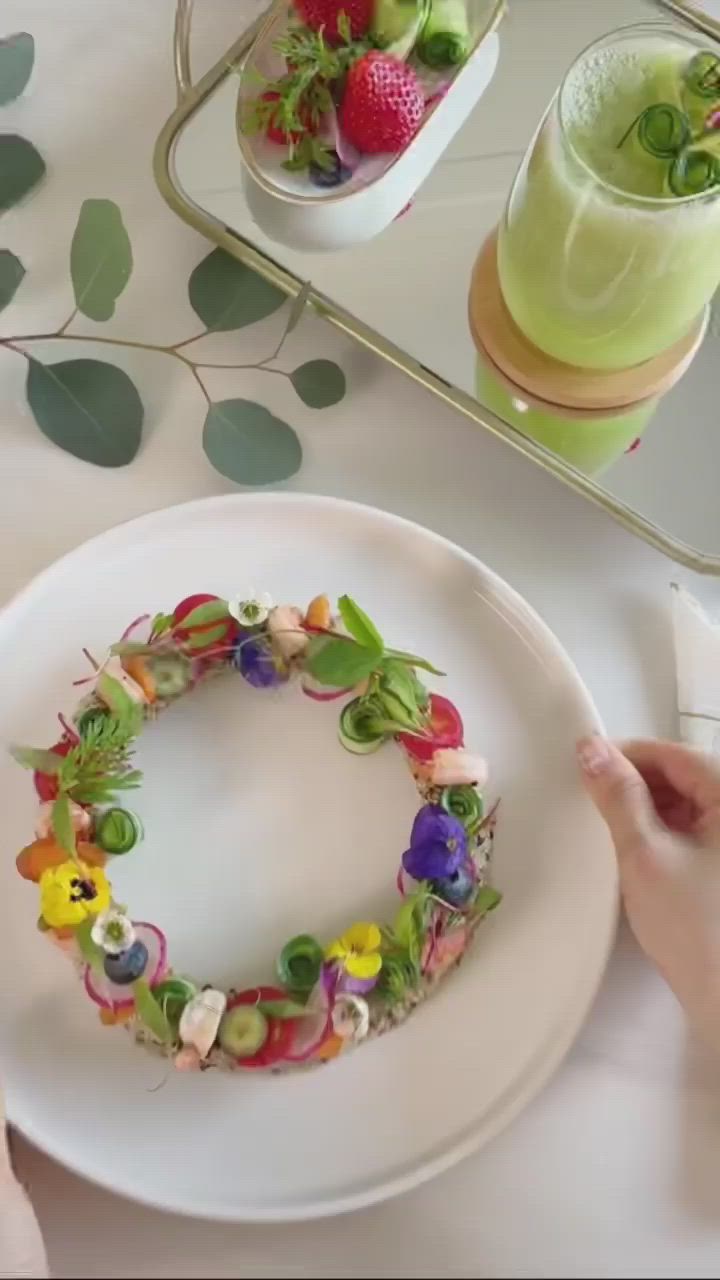 This may contain: a person is pouring sauce on a plate with vegetables and other food items in it