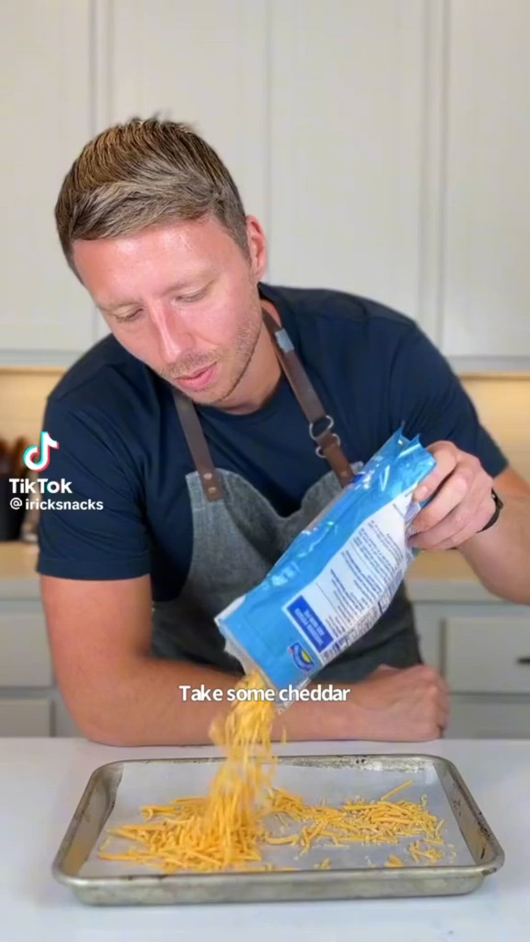 This may contain: a man in an apron is sprinkling cheese on a pan