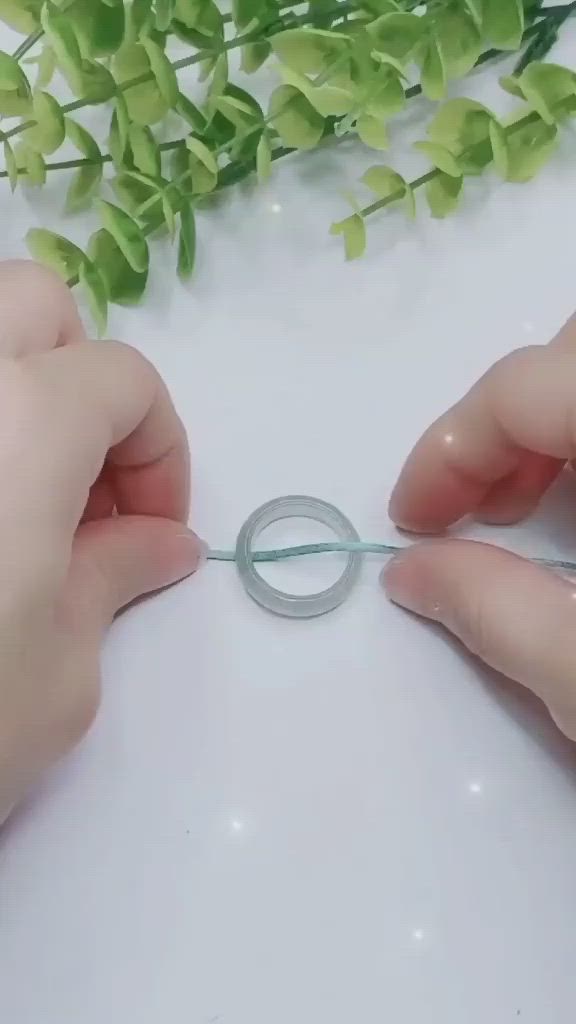 This may contain: two hands are holding scissors over a piece of paper that is shaped like an o - ring