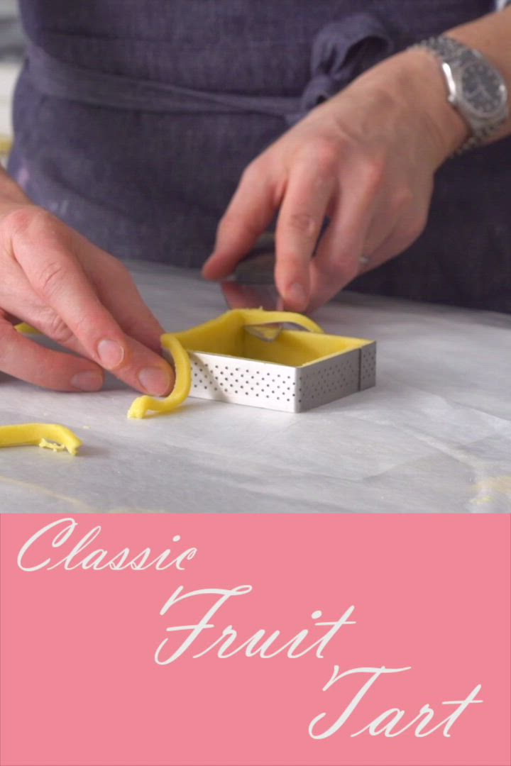 This may contain: a woman is cutting paper with scissors on a piece of fabric and the words classic fruit tart are in front of her