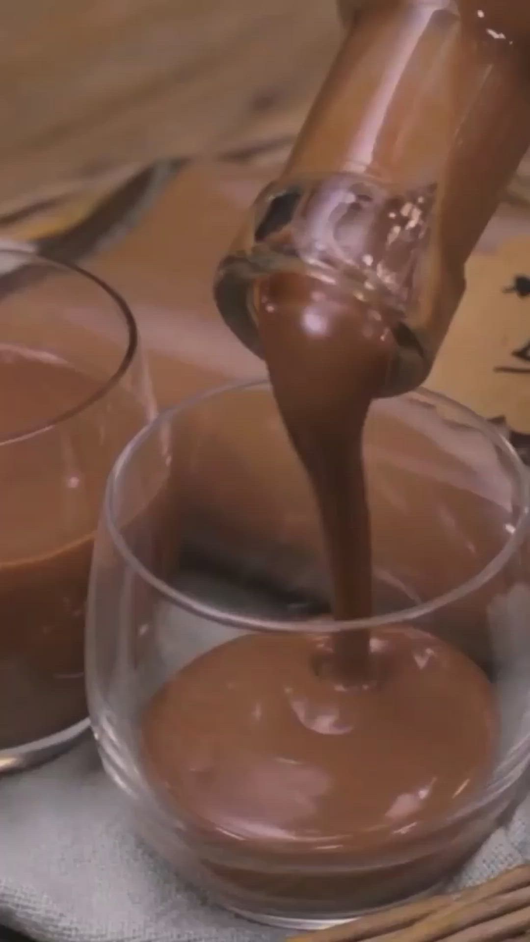 This may contain: a person pouring chocolate into a glass bowl