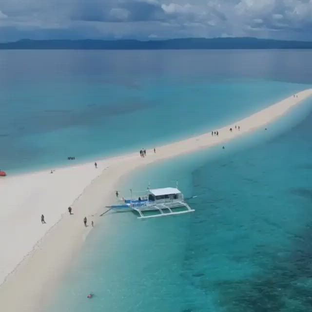 This may contain: an aerial view of a beach with people walking on the sand and in the water