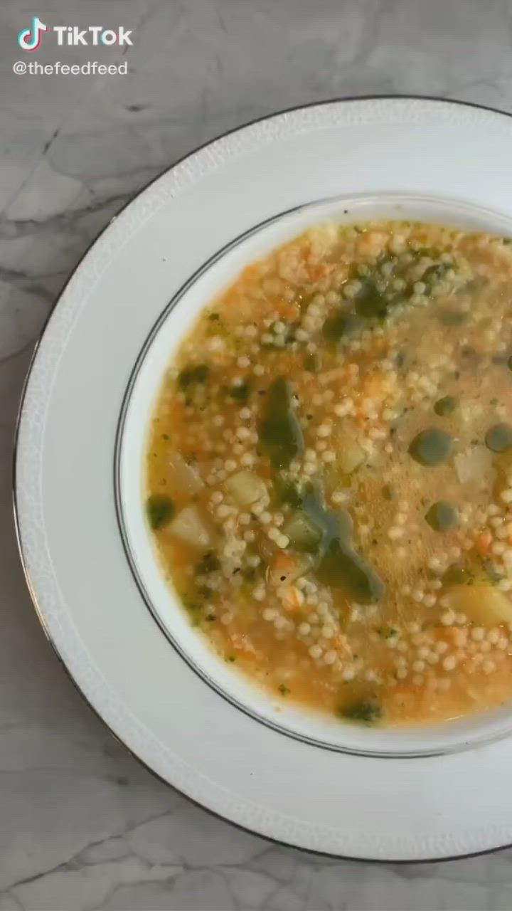 This may contain: a white bowl filled with soup on top of a table