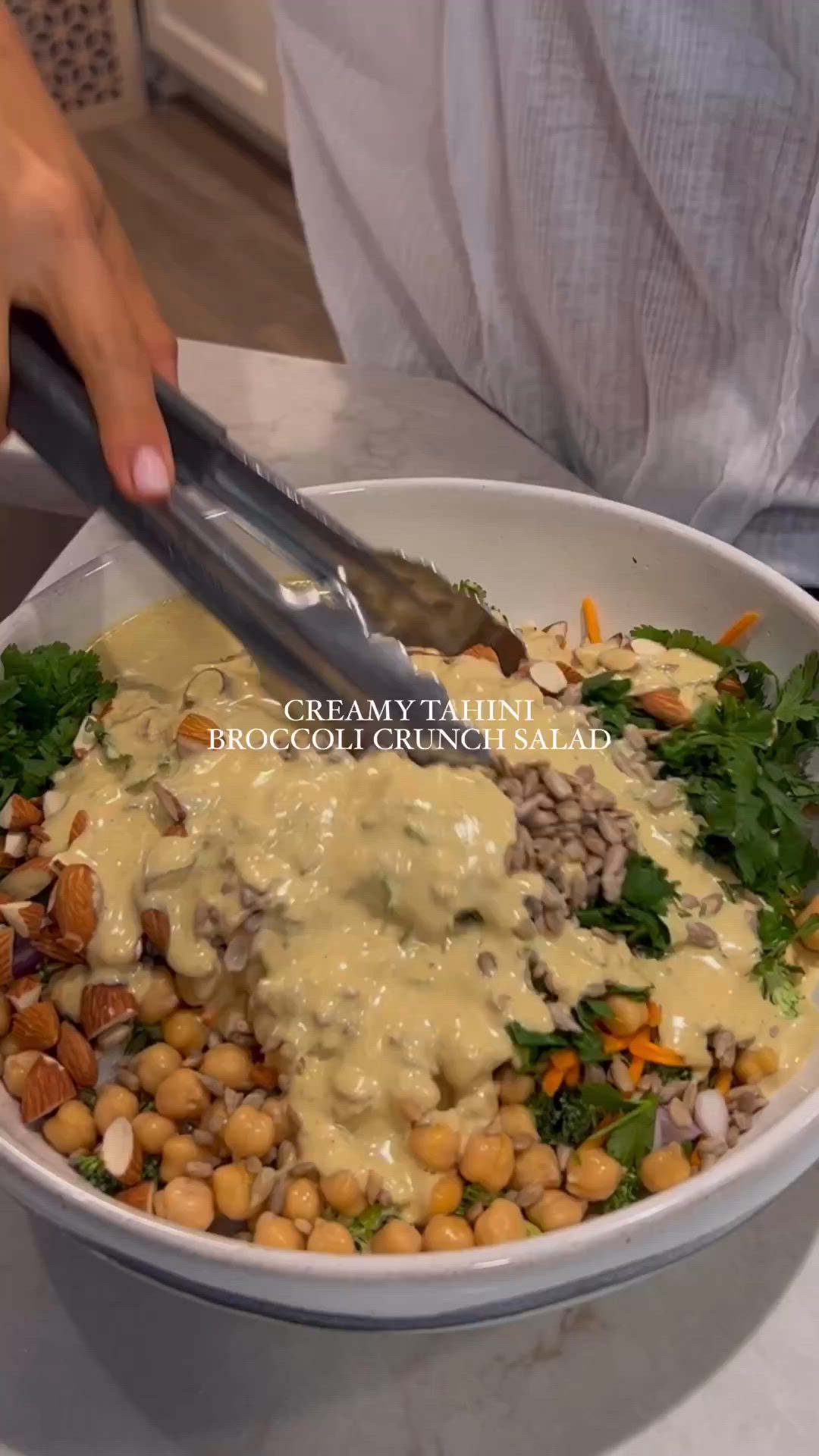 This may contain: a person is cutting into a salad in a white bowl with greens and chickpeas