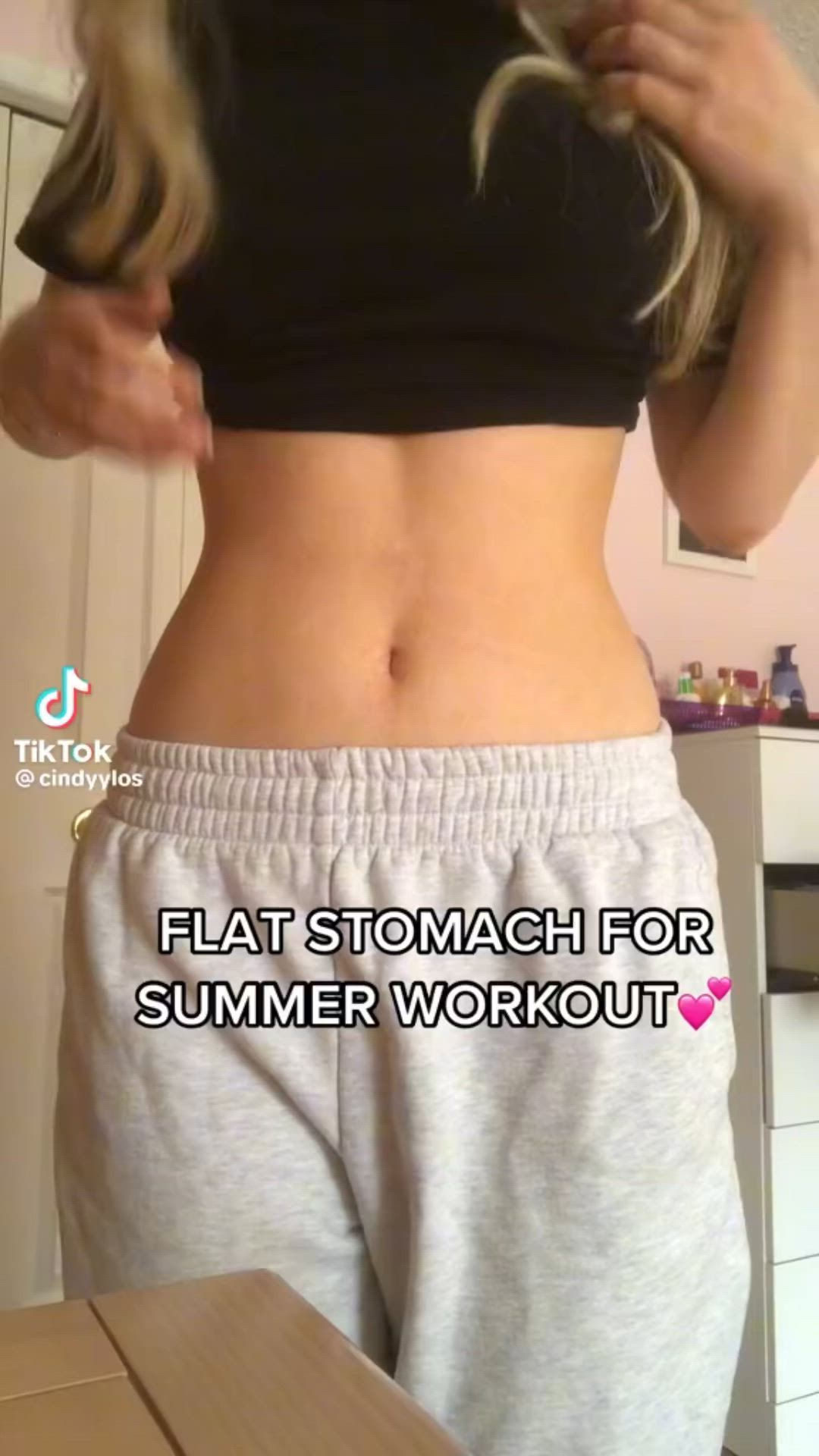 This may contain: a woman is showing off her flat stomach for summer work out with the help of someone else