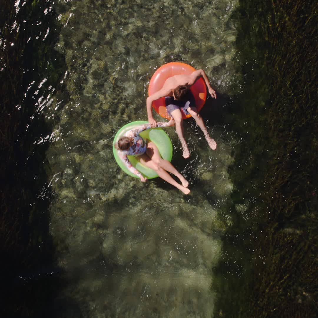 This may contain: two people are floating on an inflatable raft and one person is laying down