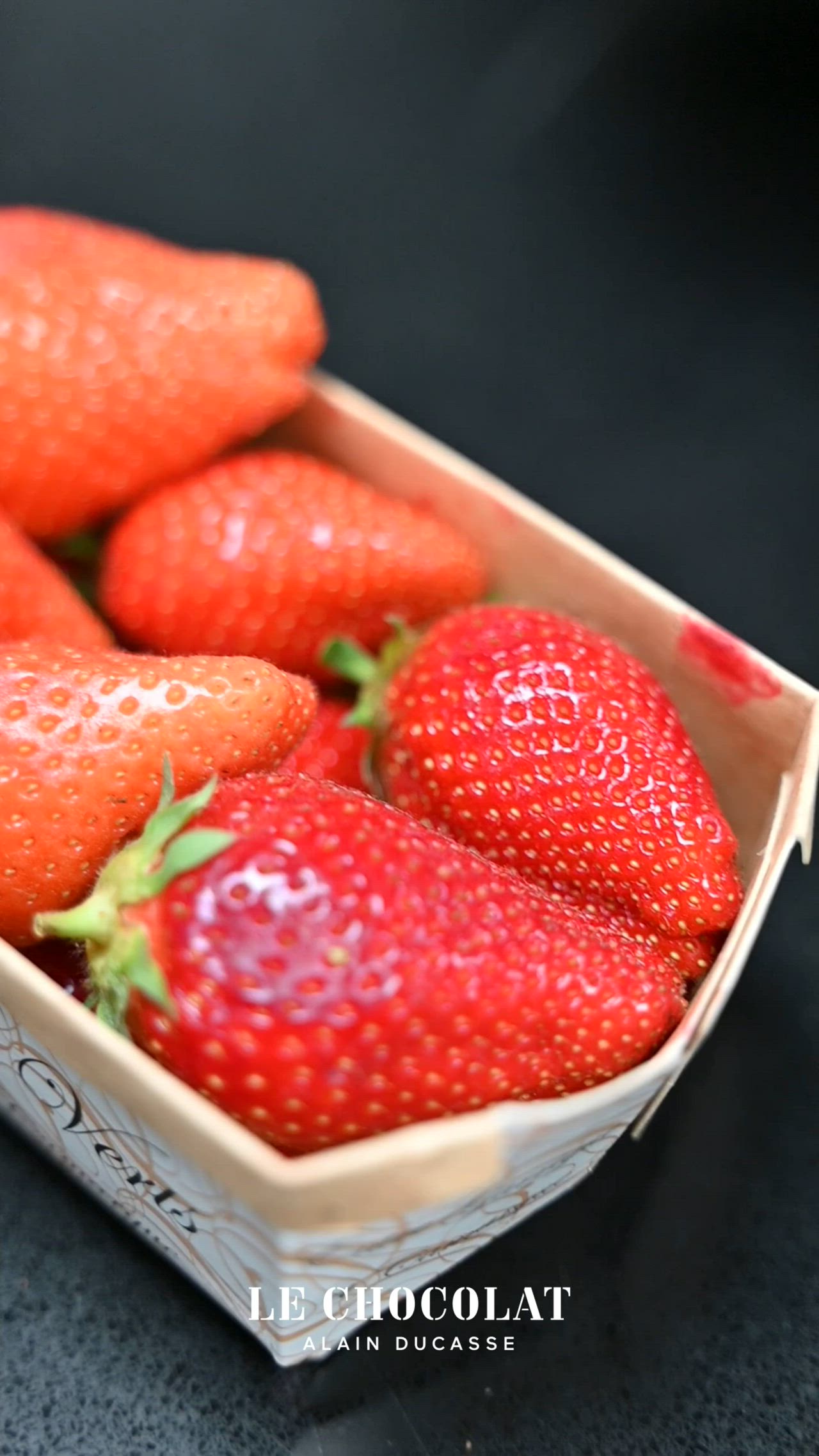 This may contain: a bowl full of strawberries sitting on top of a table