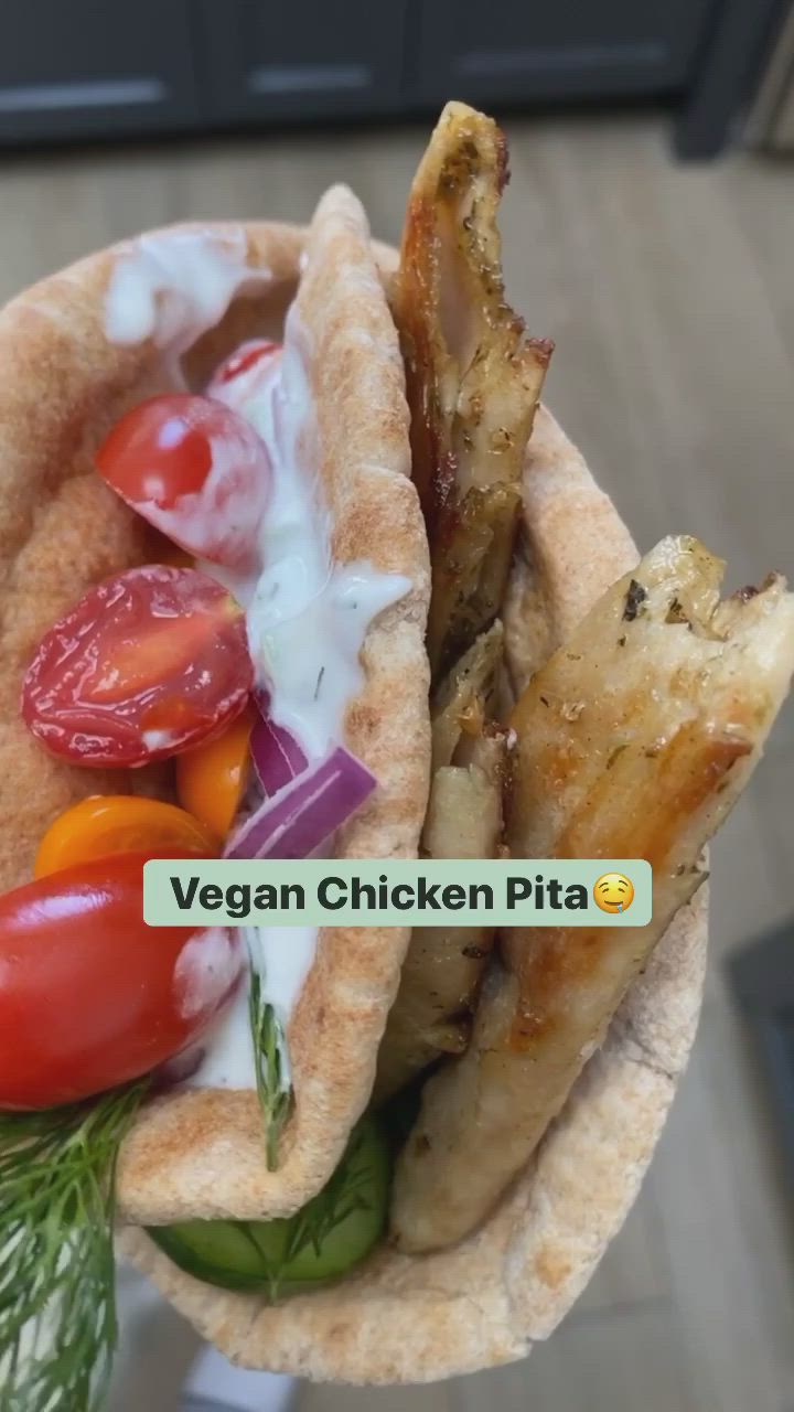 This may contain: vegan chicken pita wrap with tomatoes, lettuce and tomato on top