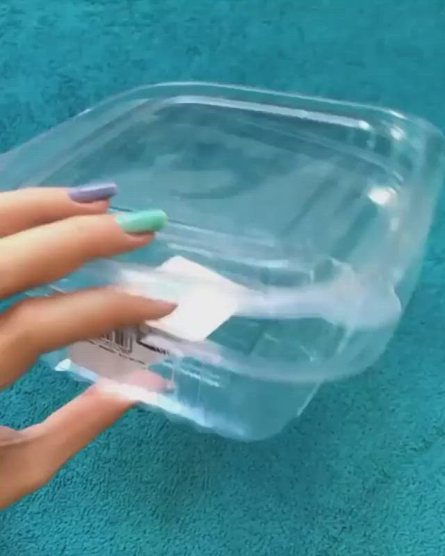 This may contain: a woman's hand holding onto a plastic container