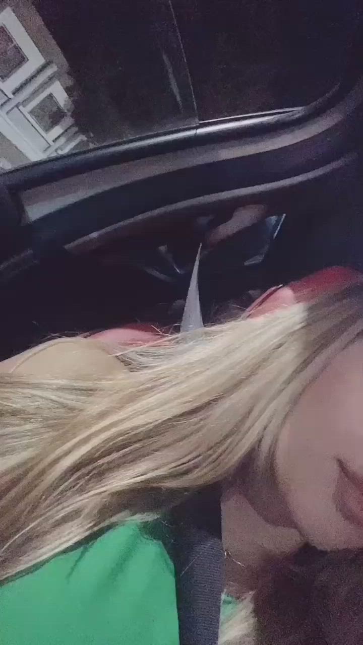 This may contain: a woman with long blonde hair laying in the back seat of a car