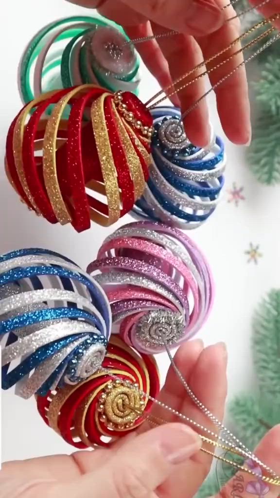 This may contain: someone is holding several christmas ornaments in their hands, and they are all different colors