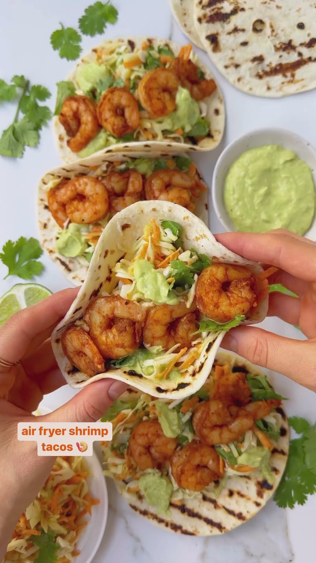 This may contain: shrimp tacos with guacamole and avocado sauce on the side