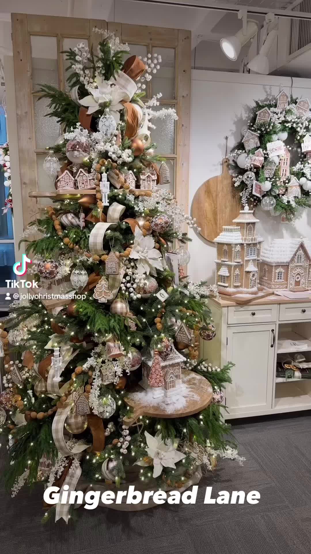 This may contain: a christmas tree decorated with white and gold ornaments