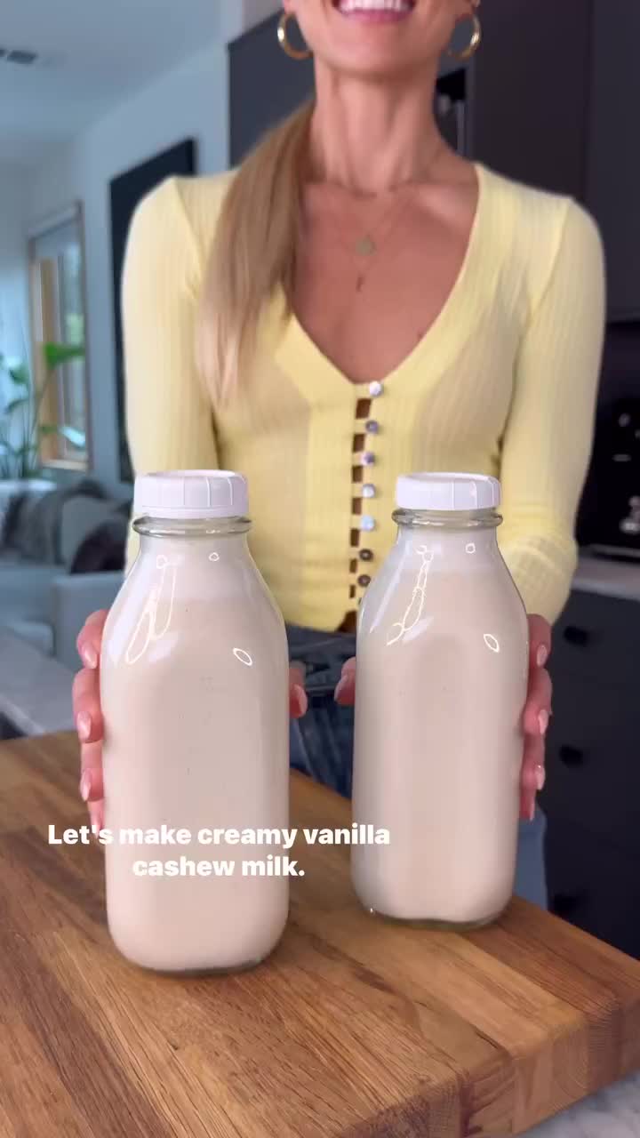 This may contain: a person pouring milk into a glass jar