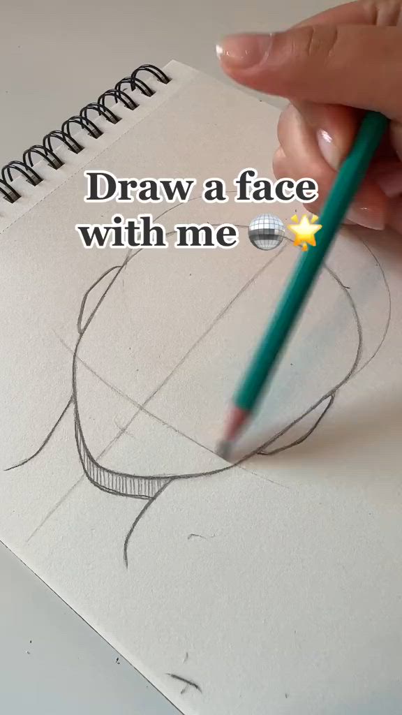 This may contain: someone drawing a face with a pencil on top of a piece of paper that says draw a face with me