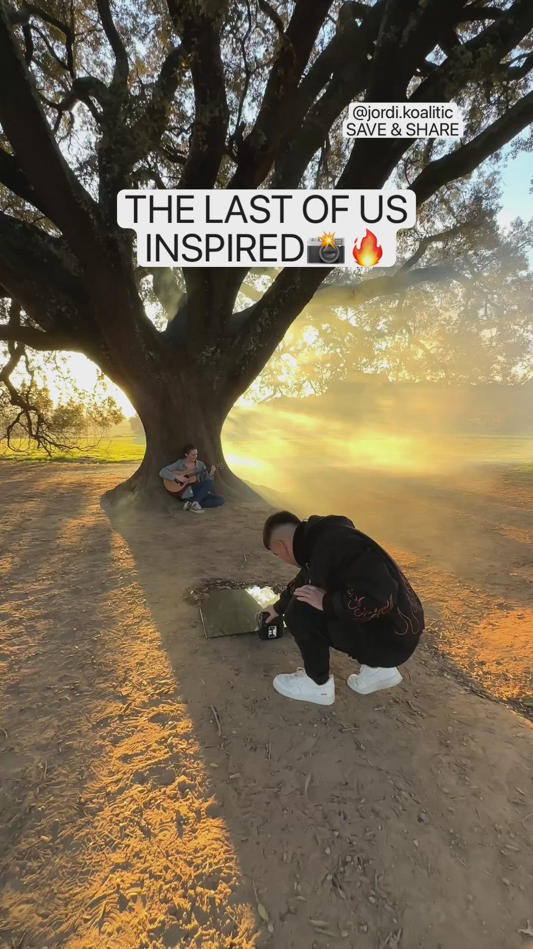 This may contain: two people sitting under a large tree on the ground next to an open fire hydrant