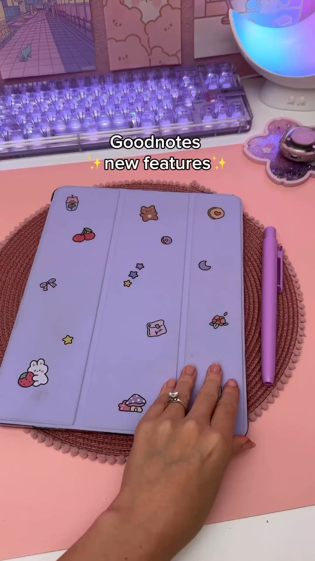 This may contain: a person is writing on an ipad with hello kitty stickers and a purple pen