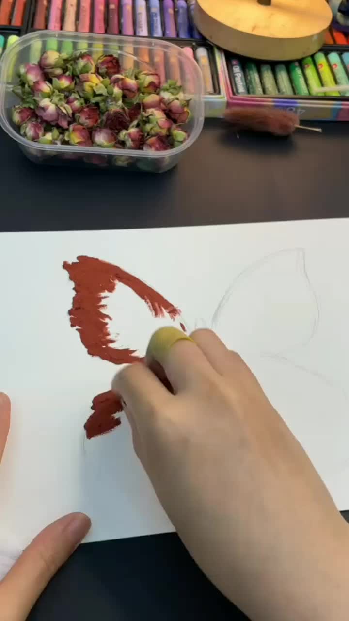 This may contain: a person is painting flowers on a piece of paper